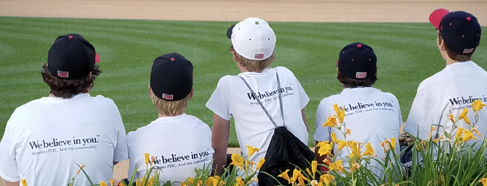 Little league baseball team wearing Bank branded tshirts.